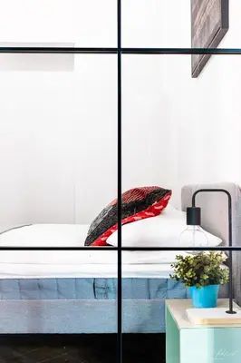 a bed with red pillows on it in a room at Center High Apartment CityBeat#1 in Kraków
