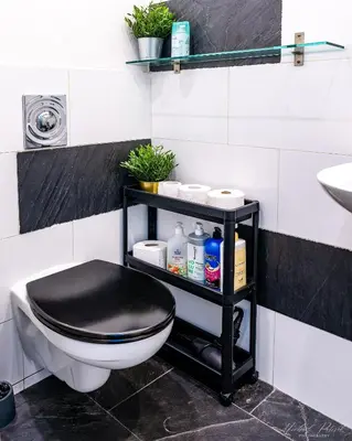 a bathroom with a black toilet and a black shelf at Center High Apartment CityBeat#1 in Kraków