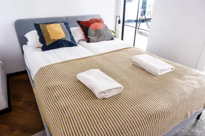 a bed with two towels on top of it at Center High Apartment CityBeat#1 in Kraków