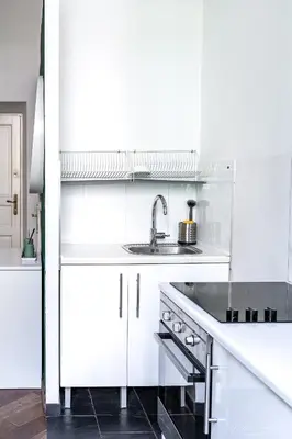a kitchen with white cabinets and a sink at Center High Apartment CityBeat#1 in Kraków