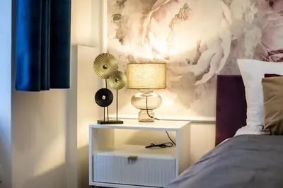 a nightstand with a lamp on it next to a bed at CracWoW K8 No.6 Apartment in Kraków