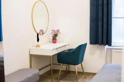 a dressing table with a mirror and a blue chair at CracWoW K8 No.6 Apartment in Kraków