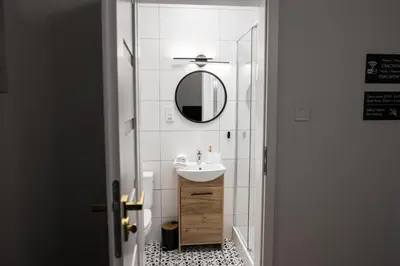 a bathroom with a sink and a mirror at CracWoW K8 No.6 Apartment in Kraków