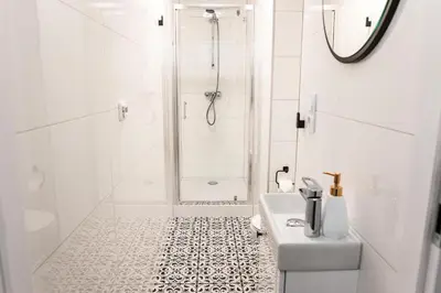 a white bathroom with a shower and a sink at CracWoW K8 No.6 Apartment in Kraków