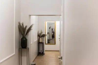 a hallway with a mirror and a potted plant at CracWoW K8 No.6 Apartment in Kraków