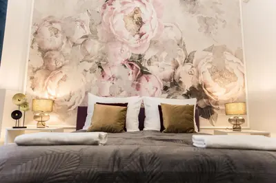 a bedroom with a pink and white floral wall mural at CracWoW K8 No.6 Apartment in Kraków