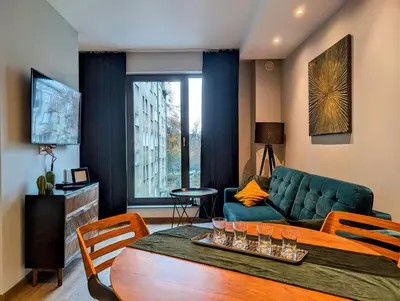 a living room with a green couch and a table at Stachowicza 5 by Homeprime in Kraków