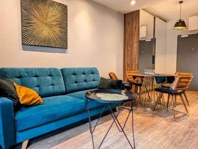 a living room with a blue couch and tables at Stachowicza 5 by Homeprime in Kraków