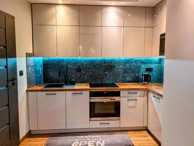 a kitchen with white cabinets and a blue counter top at Stachowicza 5 by Homeprime in Kraków