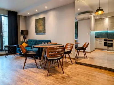 a living room with a couch and a table and chairs at Stachowicza 5 by Homeprime in Kraków