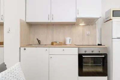 a kitchen with white cabinets and a stove at Pet-Friendly & Cozy Studio in Kraków by Noclegi Renters in Kraków
