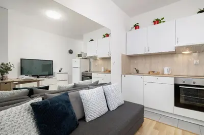 a living room with a couch and a kitchen at Pet-Friendly & Cozy Studio in Kraków by Noclegi Renters in Kraków
