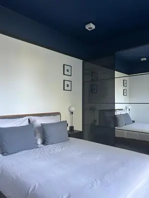 a bedroom with a large bed with a blue ceiling at Composition No. 2 in Kraków