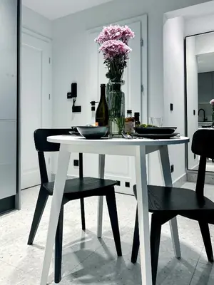 a white dining room table with a vase of flowers at Composition No. 2 in Kraków