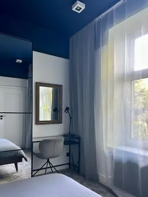 a bedroom with a bed and a chair and a window at Composition No. 2 in Kraków