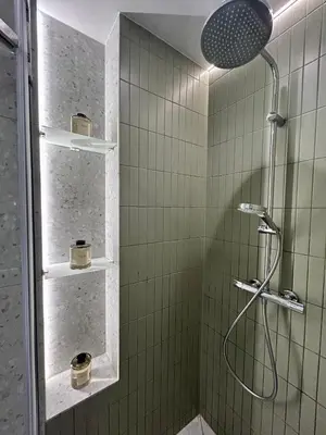 a bathroom with a shower with green tiles at Composition No. 2 in Kraków