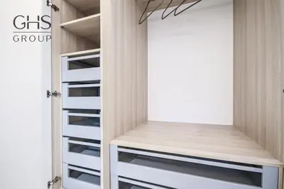a walk in closet with white shelves and a door at Ekskluzywny Apartament obok Zamku Wawelskiego in Kraków
