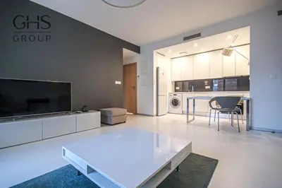 a living room with a white table and a kitchen at Ekskluzywny Apartament obok Zamku Wawelskiego in Kraków