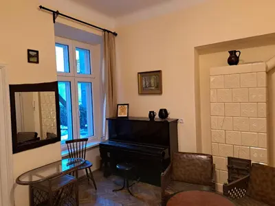 a living room with a piano and a glass table at Apartment St. Mark's Square in Kraków