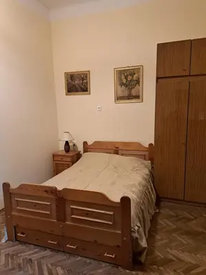 a bedroom with a wooden bed and a dresser at Apartment St. Mark's Square in Kraków