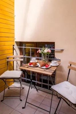a table with plates of food and flowers on it at Discover Krakow Apartments - Lubomirskiego St - Classic & Modern - Near Main Station, Netflix and AC in Kraków