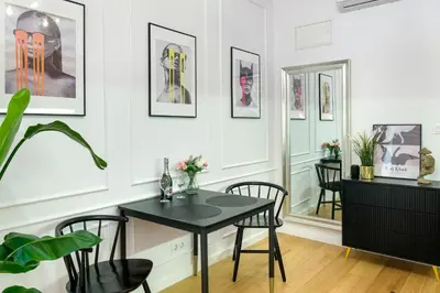 a dining room with a black table and chairs at Discover Krakow Apartments - Lubomirskiego St - Classic & Modern - Near Main Station, Netflix and AC in Kraków
