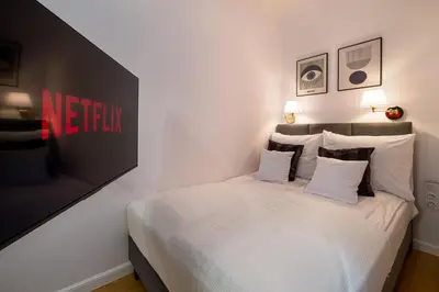 a bedroom with a bed with white sheets and pillows at Discover Krakow Apartments - Lubomirskiego St - Classic & Modern - Near Main Station, Netflix and AC in Kraków