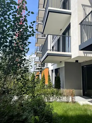 a tall apartment building with a yard of grass and flowers at Golden residence apartment in Kraków