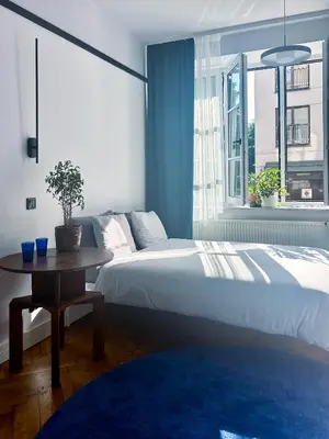 a bedroom with a bed and a table and a window at Composition 23 with blue circle in Kraków