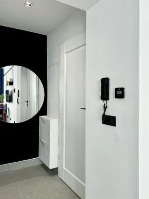 a hallway with a mirror and a white door at Composition 23 with blue circle in Kraków