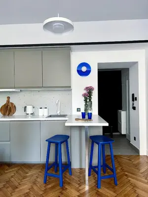 a kitchen with two blue stools in front of a counter at Composition 23 with blue circle in Kraków