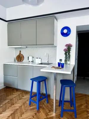 a kitchen with two blue stools and a table at Composition 23 with blue circle in Kraków