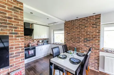 a kitchen and dining room with a brick wall at LARGE LUXURY APARTMENT WIELICZKA in Wieliczka