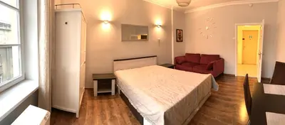 a bedroom with a bed and a red chair at Apartament S19 in Kraków