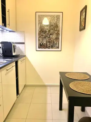 a kitchen with two tables and a picture on the wall at Apartament S19 in Kraków