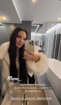 a woman taking a picture with her cell phone at Paris in Cracow Apartment in Kraków
