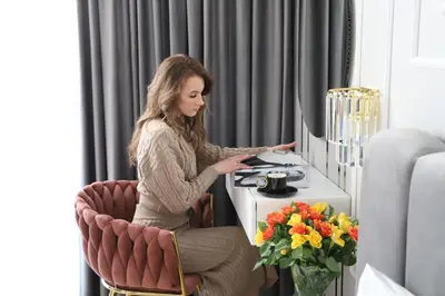 a woman sitting in a chair at a table at Paris in Cracow Apartment in Kraków