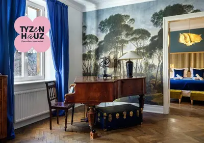 a room with a piano and a bedroom with a bed at Tyzenhauz Apartments Podwale street in Kraków