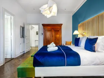 a bedroom with a large bed with blue and white at Tyzenhauz Apartments Podwale street in Kraków