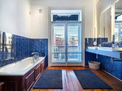 a bathroom with a tub and a large window at Tyzenhauz Apartments Podwale street in Kraków