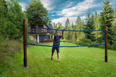 a man holding a tennis racket in front of a net at Jankówki - Dom w górach in Nowy Targ
