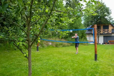 a man is playing on a blue tape in a yard at Jankówki - Dom w górach in Nowy Targ