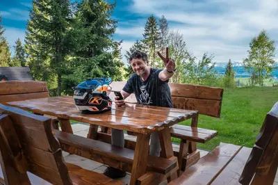 a man sitting at a picnic table with a helmet on it at Jankówki - Dom w górach in Nowy Targ
