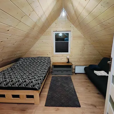 a room with a bed and a couch in a cabin at beskid.house1 in Spytkowice
