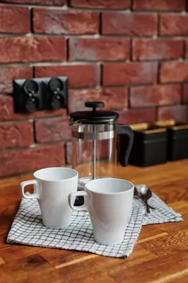 two cups on a napkin with a coffee maker at Luminous Loft - Modern Old Town Apartment - by Upstairs in Kraków