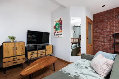 a living room with a couch and a television at Luminous Loft - Modern Old Town Apartment - by Upstairs in Kraków