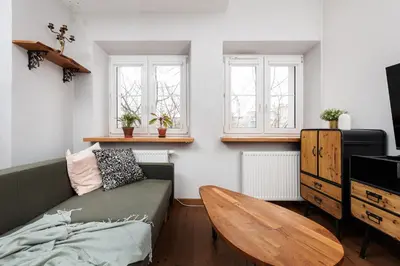 a living room with a couch and a wooden table at Luminous Loft - Modern Old Town Apartment - by Upstairs in Kraków