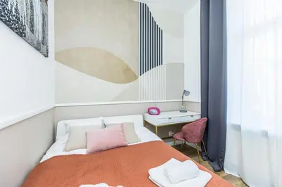a small bedroom with a bed and a desk at Nowoczesny apartament w ścisłym centrum Krakowa - by Upstairs in Kraków