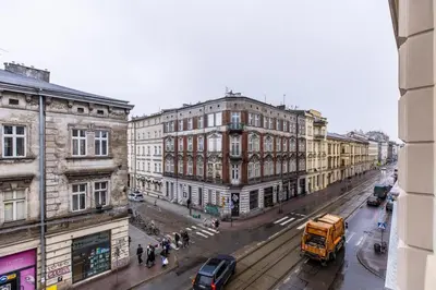 a city street with buildings and a yellow truck at Nowoczesny apartament w ścisłym centrum Krakowa - by Upstairs in Kraków