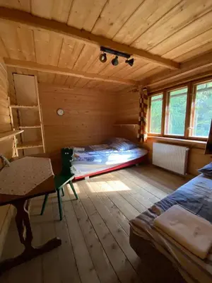 a room with a bed and a desk in a cabin at Dom na końcu świata in Ochotnica Górna